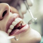 Dentist performing a cosmetic dental examination on a patient in a Colombian clinic