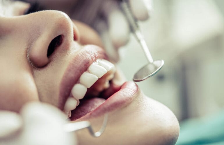 Dentist performing a cosmetic dental examination on a patient in a Colombian clinic