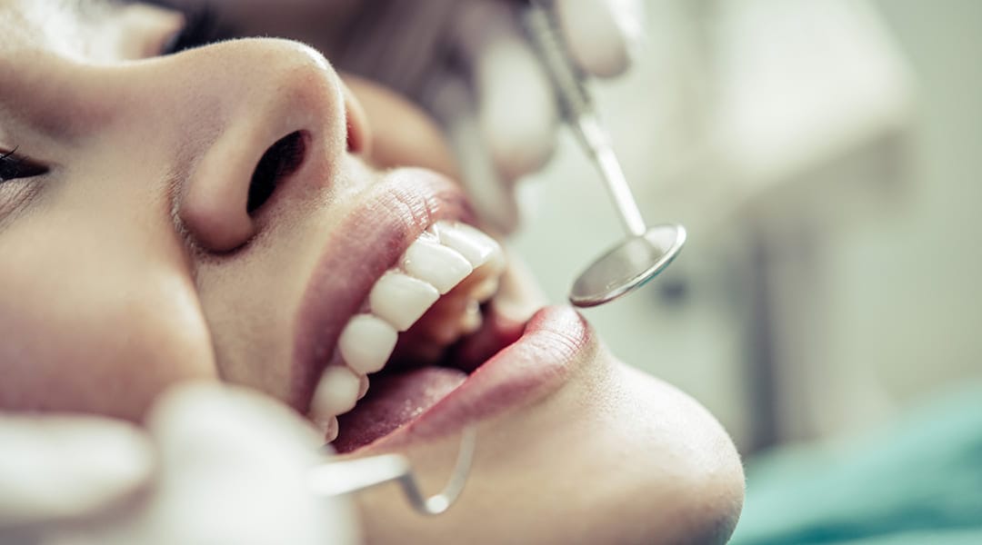 Dentist performing a cosmetic dental examination on a patient in a Colombian clinic